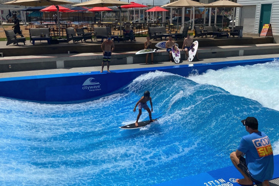 Ein Kind macht seine ersten Surfversuche auf der citywave® Deep Ellum in Texas